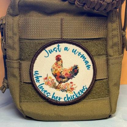 An olive green tactical pouch featuring a circular embroidered patch with a floral rooster and the text 'Just a woman who loves her chickens'.