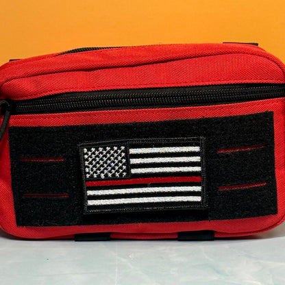 Thin Red Line American Flag Firefighter embroidered morale patch: red canvas utility pouch with a black zipper and a black front patch featuring a black-and-white American flag with a single red stripe, set against a solid orange background.
