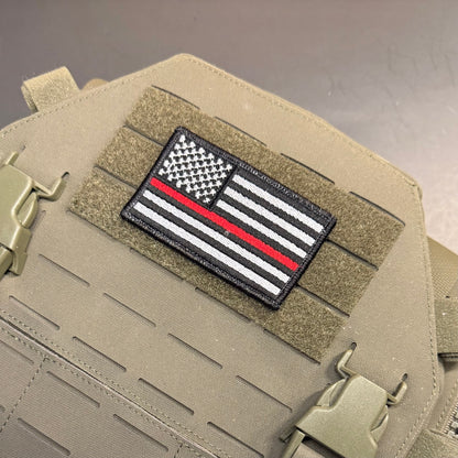 Thin Red Line American Flag Firefighter embroidered morale patch: black, white, and red 'Thin Red Line' American flag embroidered patch mounted on a tan tactical vest with velcro and quick-release buckles.
