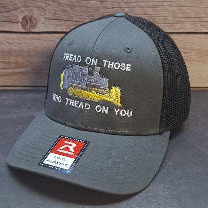 Gray cap with embroidered design and text on a wooden surface
