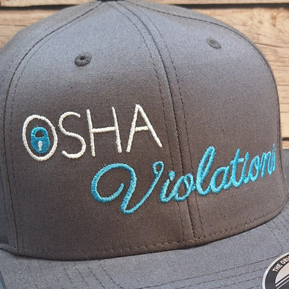 Gray cap with 'OSHA Violations' text on a wooden surface