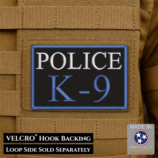 A rectangular tactical patch reading 'POLICE K-9' in white and blue on a black background with a blue border, shown attached to tan webbing. Text at the bottom says 'VELCRO HOOK BACKING LOOP SIDE SOLD SEPARATELY,' and a 'Made in Knoxville Tennessee' badge appears in the lower right.