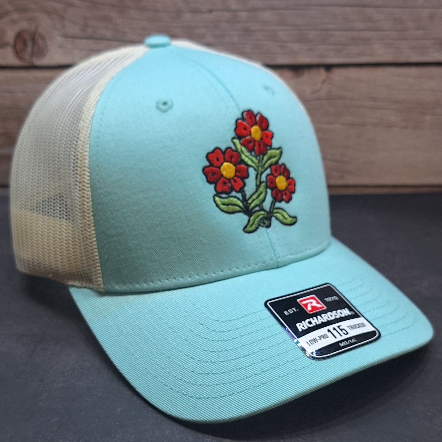 Light blue cap with floral embroidery and Richardson logo on a dark surface.
