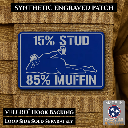 15% Stud 85% Muffin Funny Dad Bod laser-engraved synthetic morale patch: a rectangular blue synthetic patch with white engraved text reading “15% STUD 85% MUFFIN” and a white line drawing of a person lying down holding a phone.