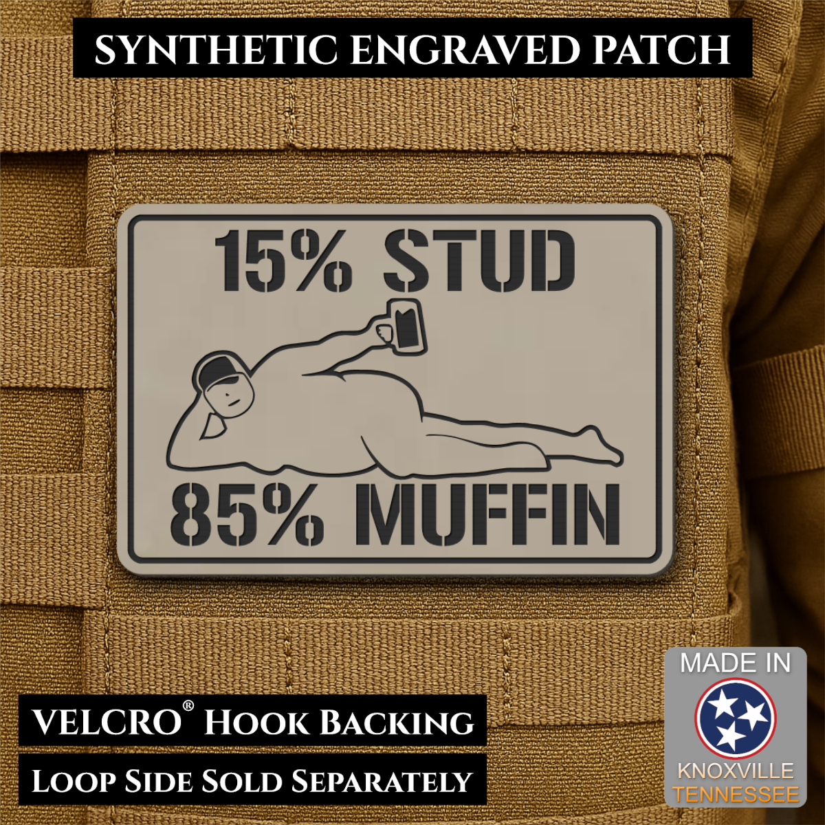 15% Stud 85% Muffin Funny Dad Bod laser-engraved synthetic morale patch: a rectangular synthetic engraved patch mounted on tan tactical MOLLE webbing. The patch is light gray with black text reading “15% STUD 85% MUFFIN” and a.