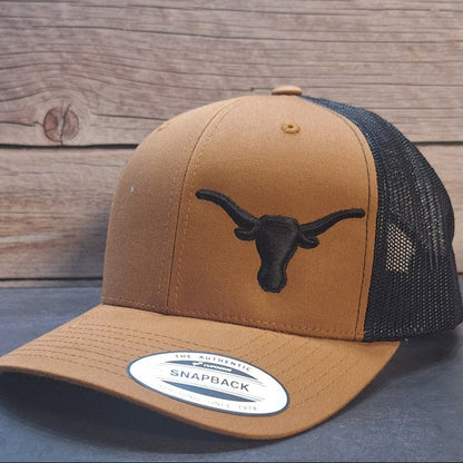 Brown and black trucker cap with a logo on a wooden surface