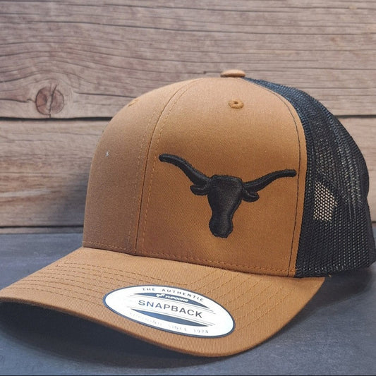 Brown and black trucker cap with a logo on a wooden surface