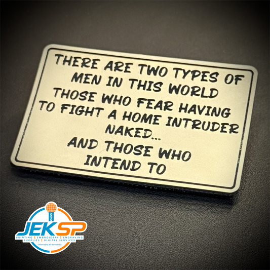 A rectangular metal sign with rounded corners featuring a humorous quote about men, displayed on a dark textured surface. A logo for 'JEKSP Custom Engraving Services' is visible in the bottom-left corner.