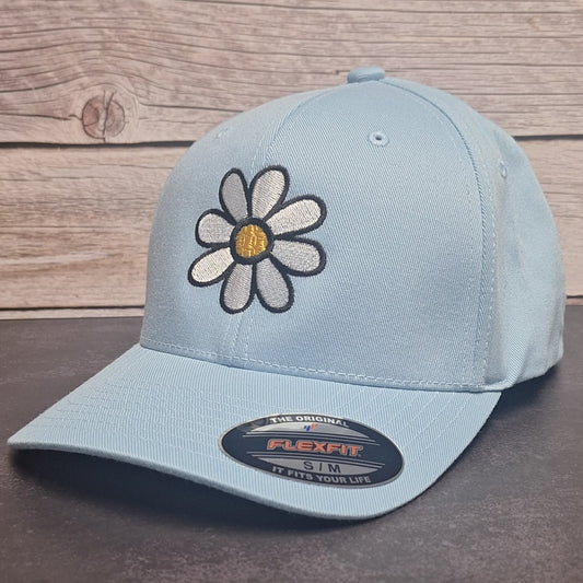 Light blue cap with a daisy flower design on a wooden surface