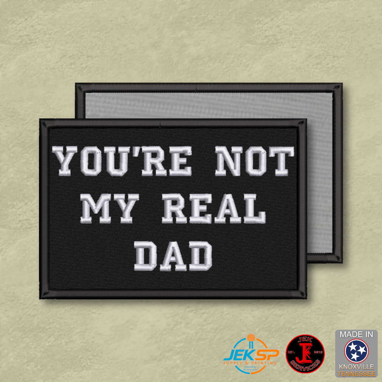 You're Not My Real Dad funny embroidered morale patch with white lettering on black background and Velcro® hook backing.